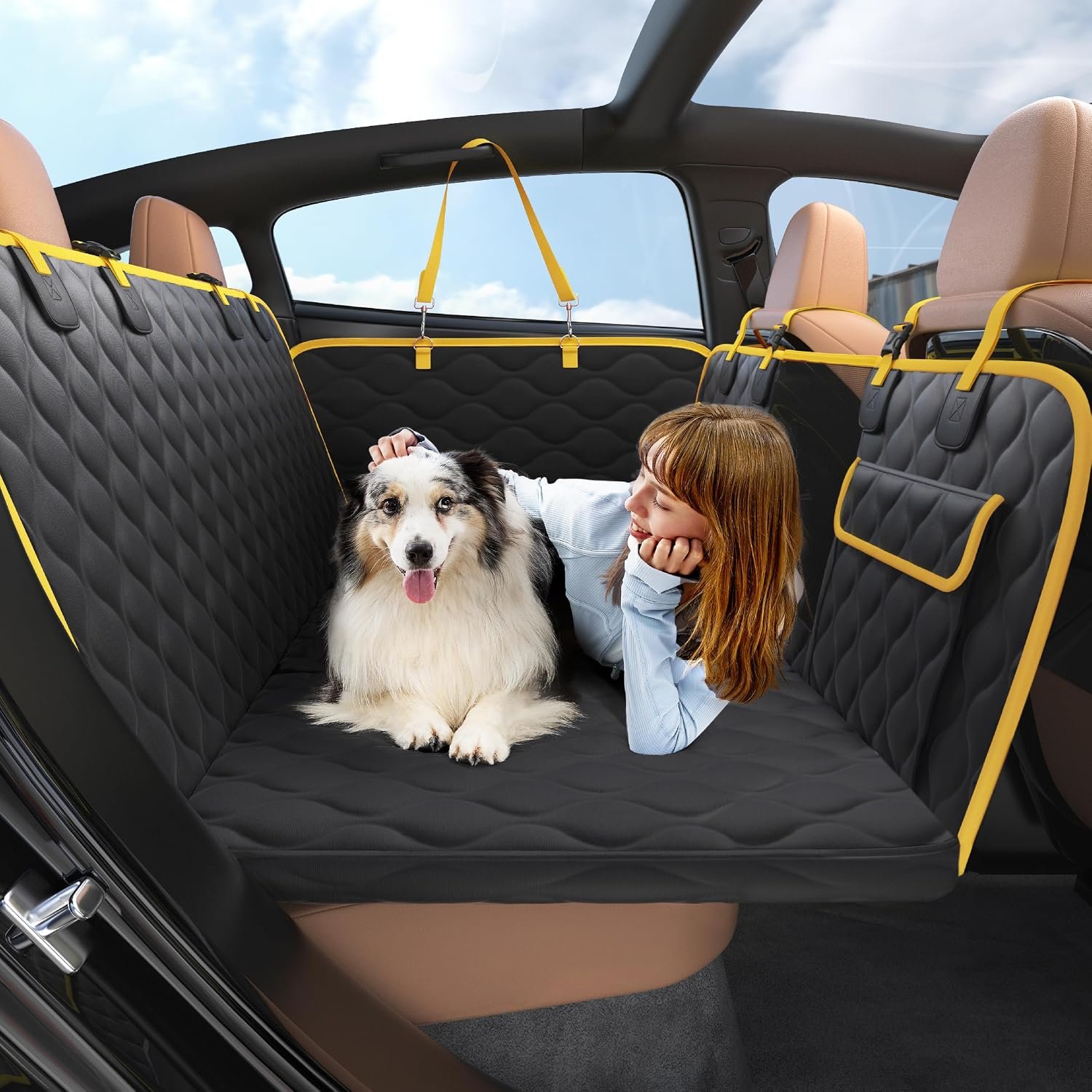 LE SURE black back seat extender with yellow trim installed in a car back seat with a dog